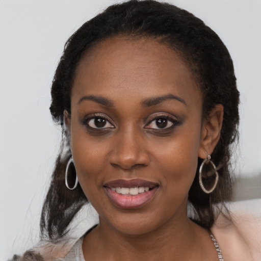 Joyful black young-adult female with long  black hair and brown eyes