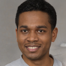 Joyful black young-adult male with short  black hair and brown eyes