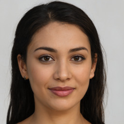 Joyful latino young-adult female with long  brown hair and brown eyes