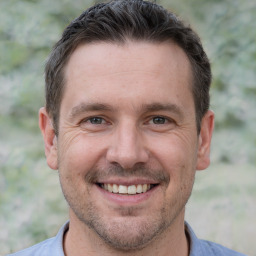 Joyful white adult male with short  brown hair and brown eyes