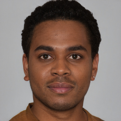 Joyful latino young-adult male with short  brown hair and brown eyes