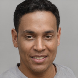 Joyful latino young-adult male with short  brown hair and brown eyes