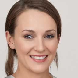 Joyful white young-adult female with medium  brown hair and grey eyes