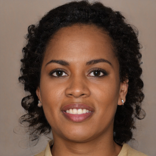 Joyful black young-adult female with long  brown hair and brown eyes