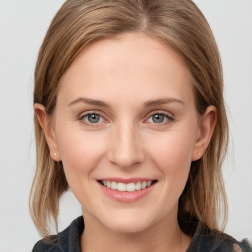 Joyful white young-adult female with medium  brown hair and grey eyes