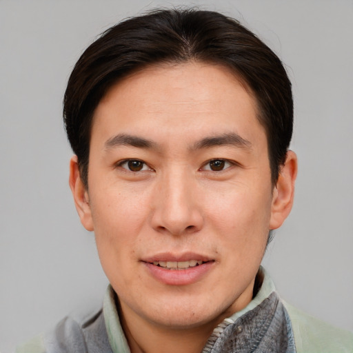 Joyful asian young-adult male with short  brown hair and brown eyes