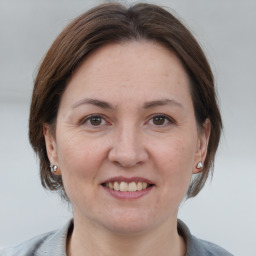 Joyful white adult female with medium  brown hair and brown eyes