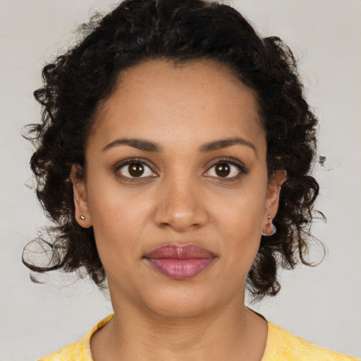 Joyful black young-adult female with medium  brown hair and brown eyes