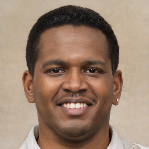 Joyful latino young-adult male with short  brown hair and brown eyes
