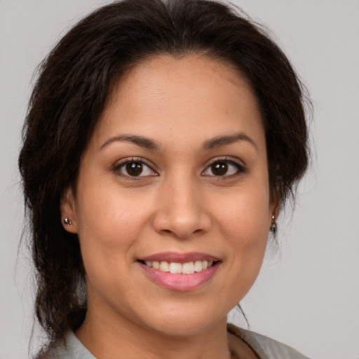 Joyful latino young-adult female with medium  brown hair and brown eyes