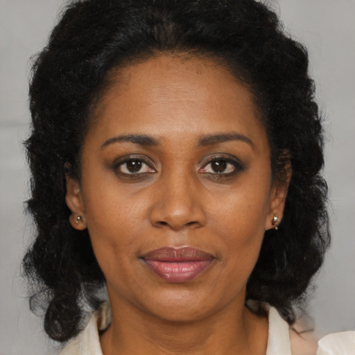 Joyful black adult female with medium  brown hair and brown eyes