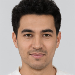 Joyful white young-adult male with short  black hair and brown eyes