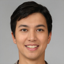 Joyful asian young-adult male with short  black hair and brown eyes