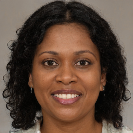 Joyful black adult female with medium  brown hair and brown eyes