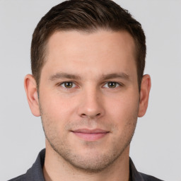 Joyful white young-adult male with short  brown hair and grey eyes