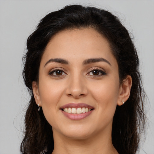 Joyful latino young-adult female with long  brown hair and brown eyes