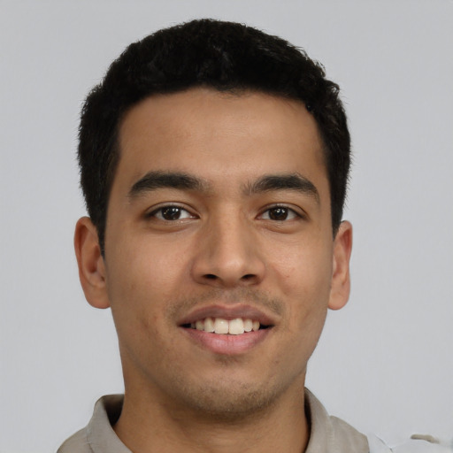 Joyful latino young-adult male with short  black hair and brown eyes