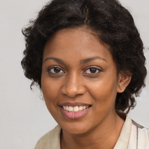 Joyful black young-adult female with long  brown hair and brown eyes
