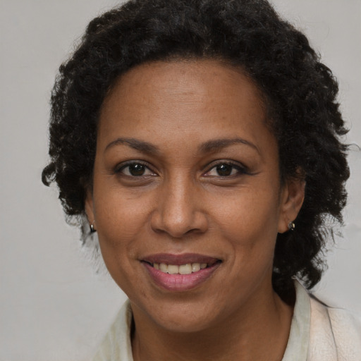 Joyful black adult female with long  brown hair and brown eyes