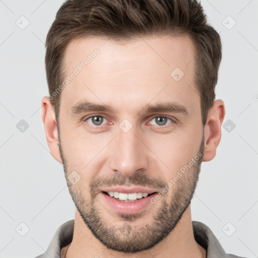 Joyful white young-adult male with short  brown hair and grey eyes