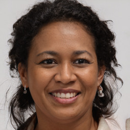 Joyful black adult female with medium  brown hair and brown eyes