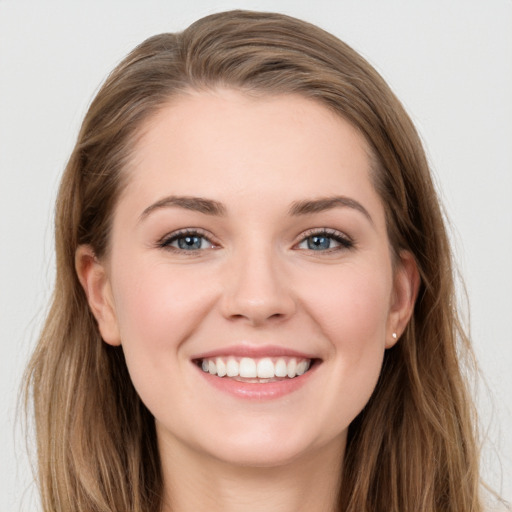 Joyful white young-adult female with long  brown hair and grey eyes