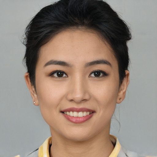 Joyful asian young-adult female with short  brown hair and brown eyes