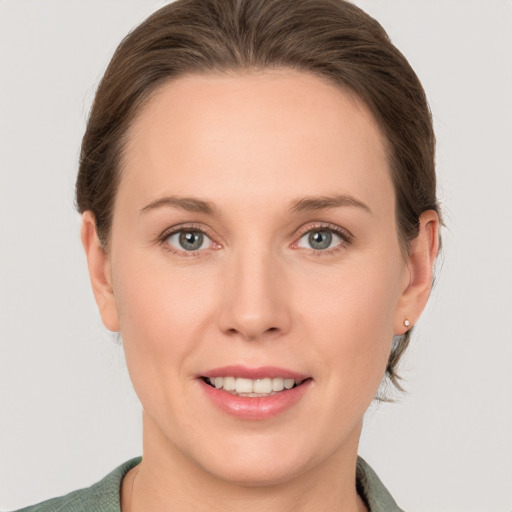 Joyful white young-adult female with short  brown hair and grey eyes