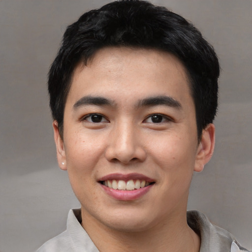 Joyful asian young-adult male with short  black hair and brown eyes