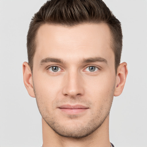 Joyful white young-adult male with short  brown hair and grey eyes