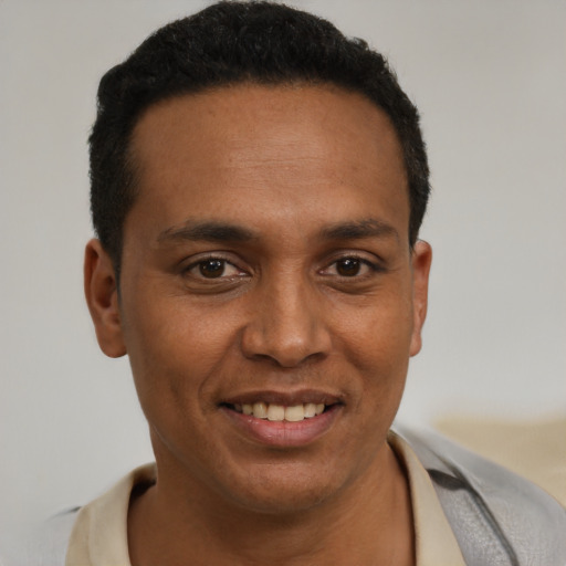 Joyful latino young-adult male with short  black hair and brown eyes