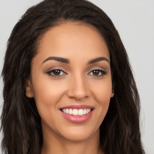 Joyful latino young-adult female with long  brown hair and brown eyes