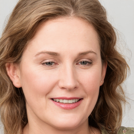 Joyful white young-adult female with medium  brown hair and blue eyes