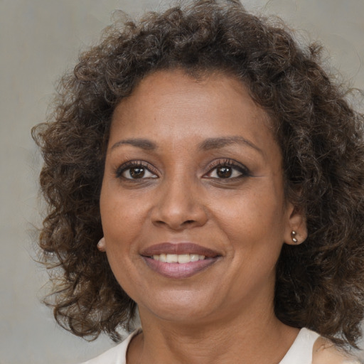 Joyful black adult female with medium  brown hair and brown eyes