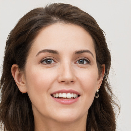 Joyful white young-adult female with long  brown hair and grey eyes