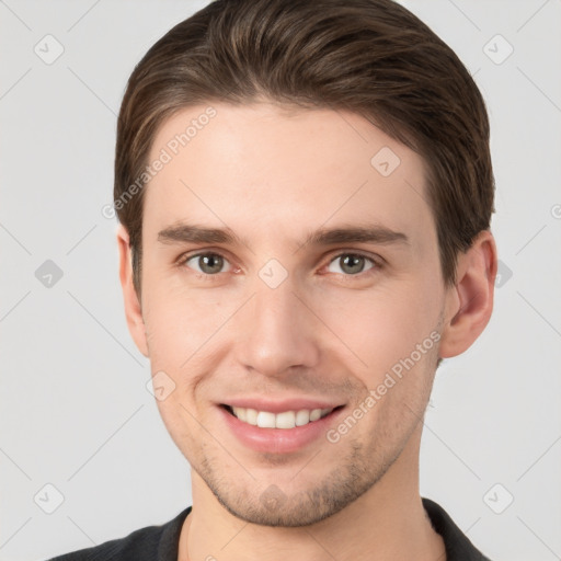 Joyful white young-adult male with short  brown hair and grey eyes