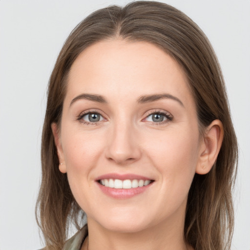 Joyful white young-adult female with long  brown hair and grey eyes