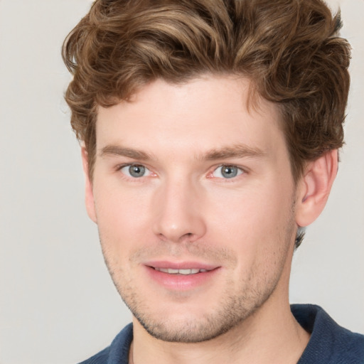 Joyful white young-adult male with short  brown hair and blue eyes