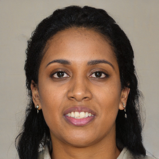 Joyful black young-adult female with long  black hair and brown eyes