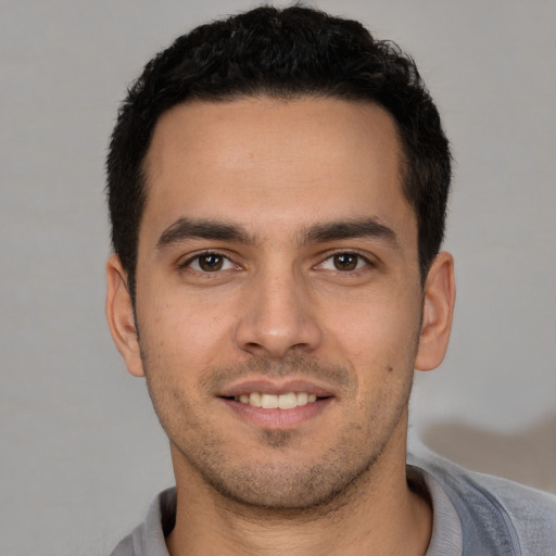 Joyful white young-adult male with short  black hair and brown eyes