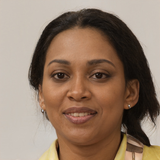 Joyful black adult female with medium  brown hair and brown eyes