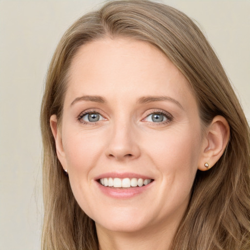 Joyful white young-adult female with long  brown hair and blue eyes