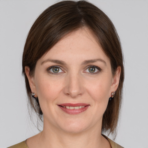 Joyful white young-adult female with medium  brown hair and grey eyes