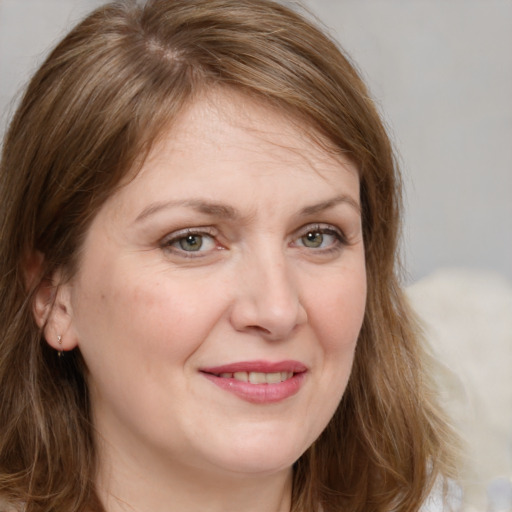 Joyful white adult female with medium  brown hair and green eyes