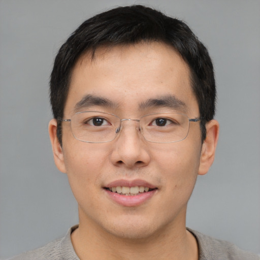 Joyful asian adult male with short  brown hair and brown eyes
