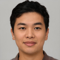 Joyful asian young-adult male with short  black hair and brown eyes