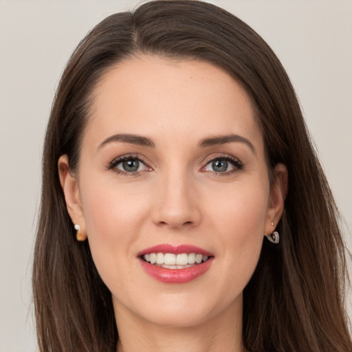 Joyful white young-adult female with long  brown hair and grey eyes