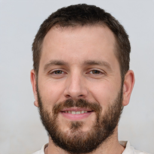 Joyful white young-adult male with short  brown hair and brown eyes