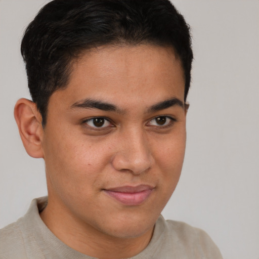 Joyful latino young-adult male with short  brown hair and brown eyes