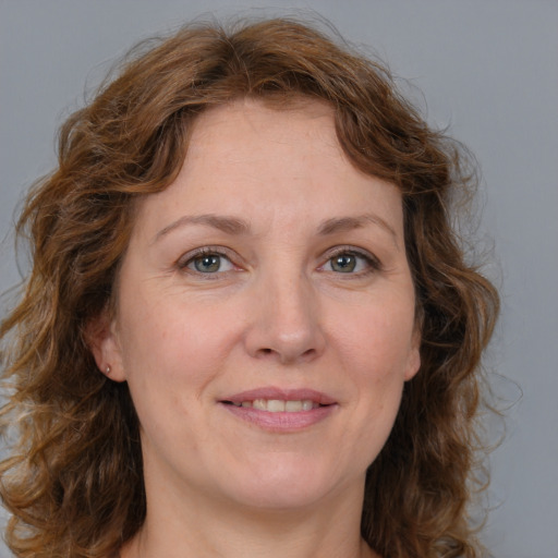 Joyful white adult female with medium  brown hair and blue eyes